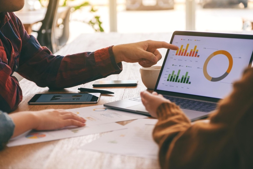Someone pointing at a screen with charts
