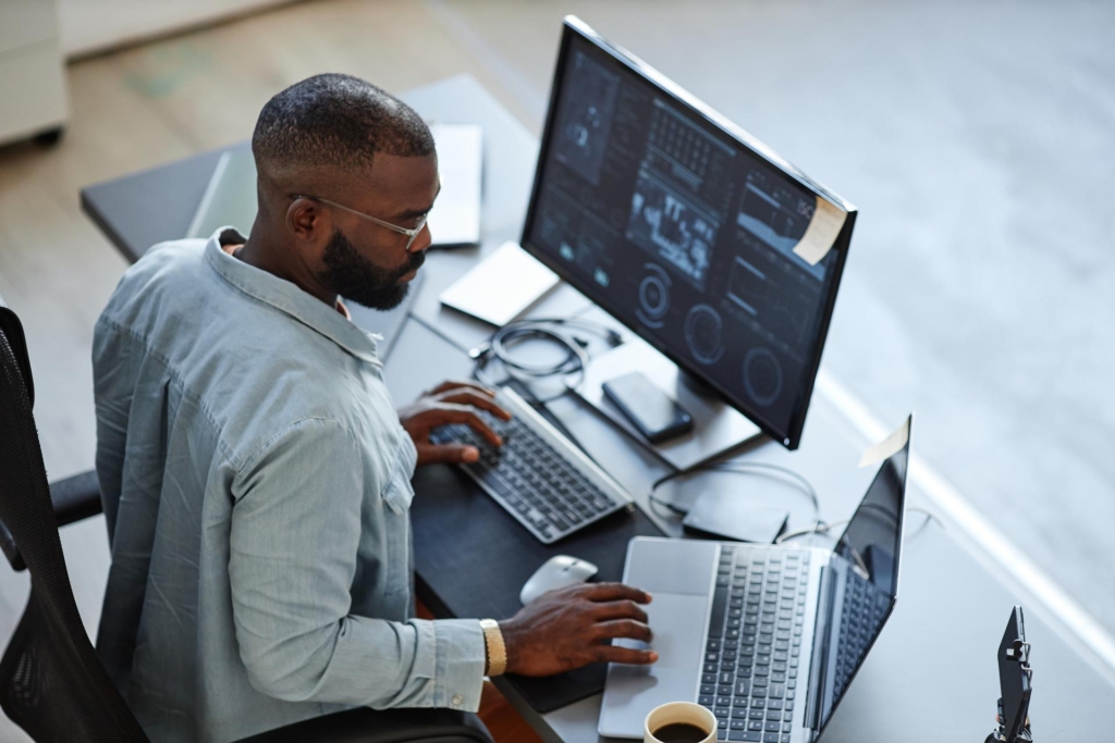 Mann am Computer mit Dual-Monitor
